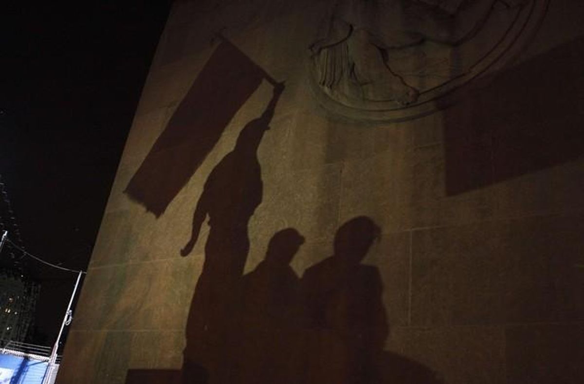 L’ombra d’un grup de persones que celebraven la mort d’Ussama bin Laden es reflecteix en una paret d’un edifici de la zona zero, a Nova York.