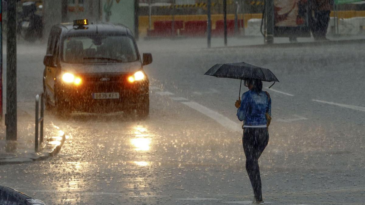 Persona caminando bajo la lluvia en Barcelona.