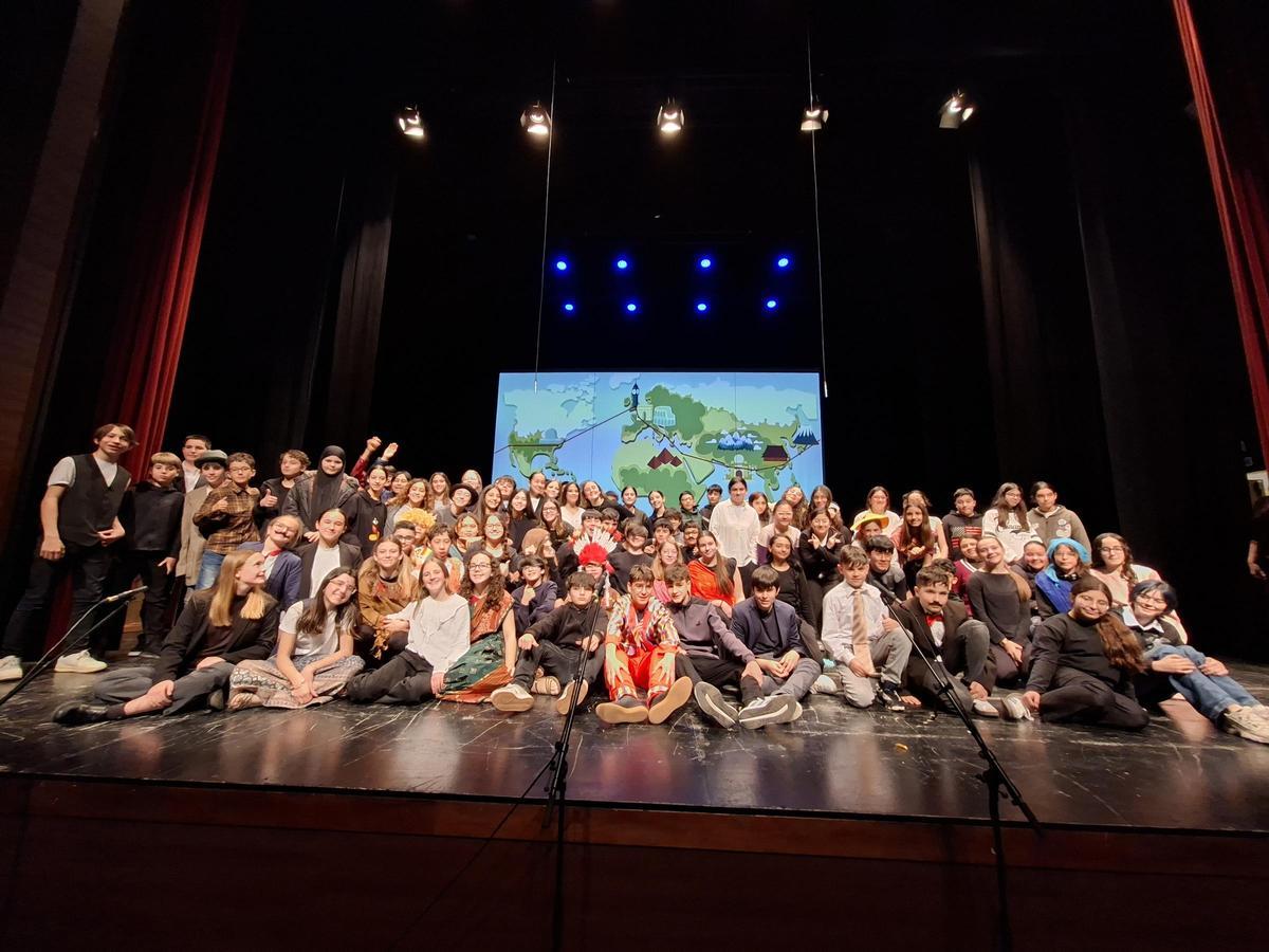 Foto de grup de l’alumnat i el professorat de l'IES Jaume I d'Ontinyent a l’escenari del Teatre Echegaray en acabar la representació de 'La volta al món en 80 dies'.