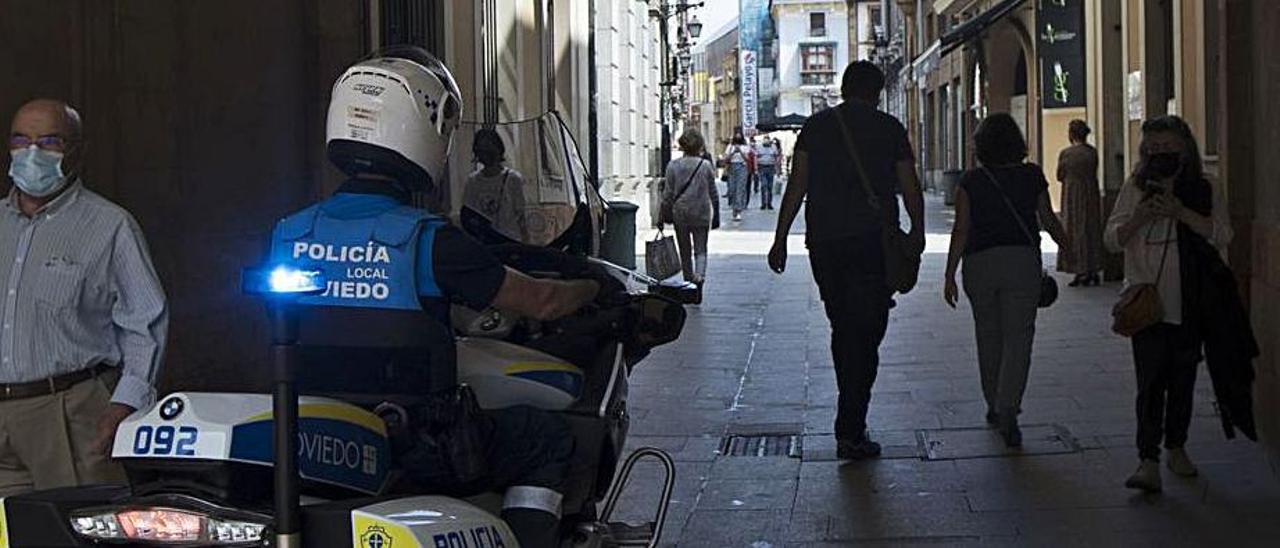 Una moto de la Policía Local patrullando ayer en la calle Cimadevilla. | M. L.