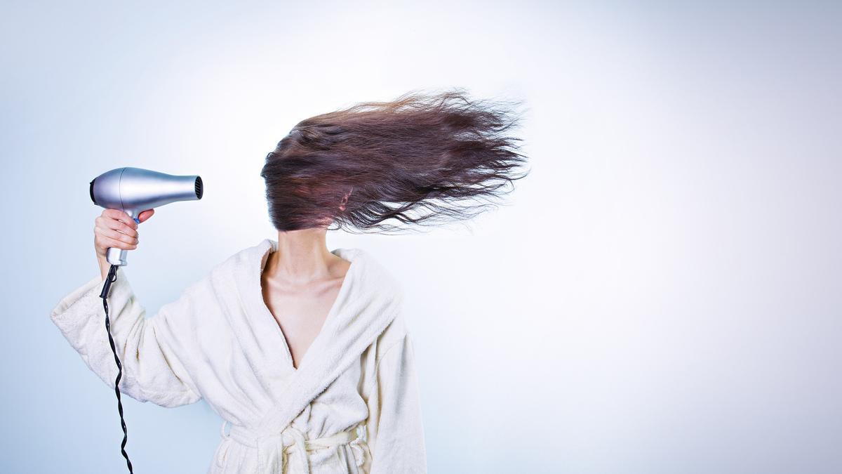 Una dona assecant-se els cabells