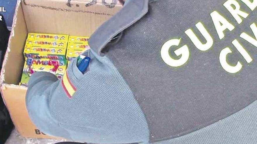 Un guardia civil abre una caja llena de ´bombetas´.