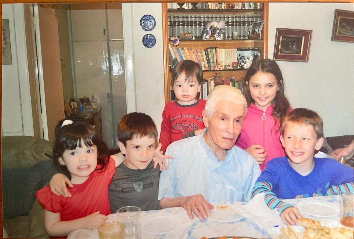 José Estrada rideado de sus bisnietos, en su casa de Comodoro Rivadavia.