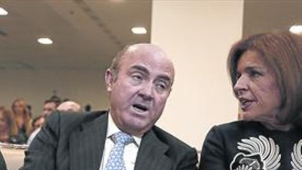 El ministro de Economía, Luis de Guindos, con Ana Botella, ayer una conferencia en Madrid.