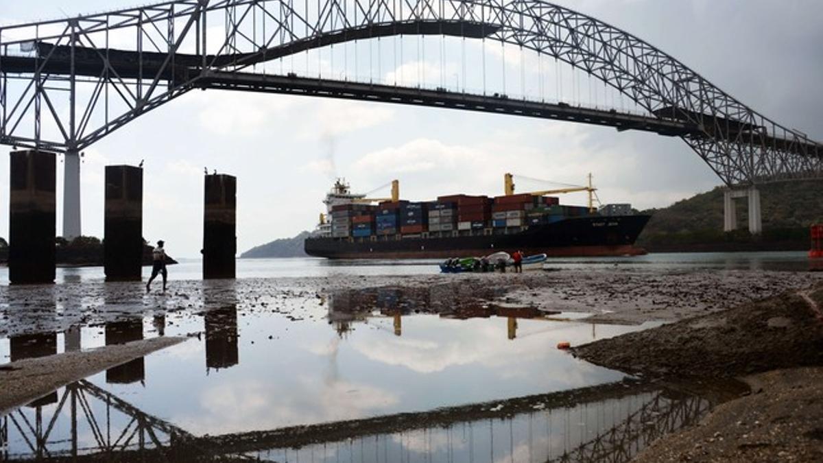 Un mercante pasa por debajo del Puente de América, en el Canal de Panamá