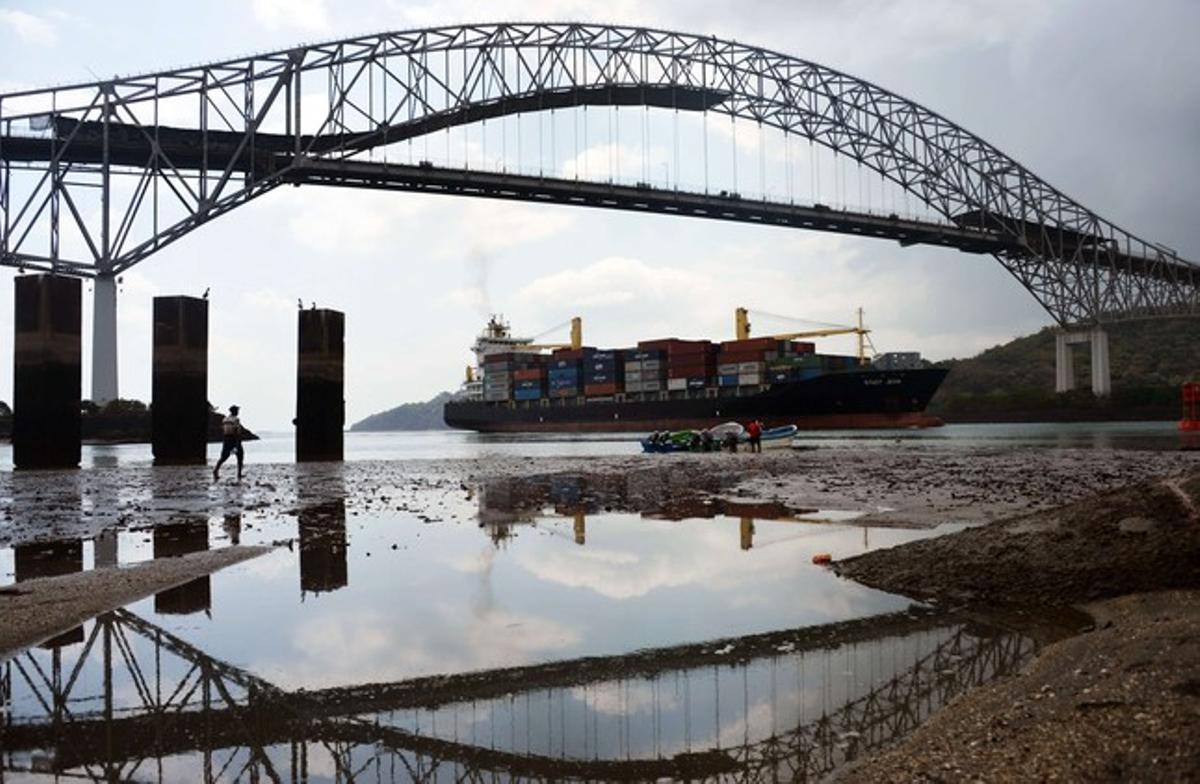 Un mercante pasa por debajo del Puente de América, en el Canal de Panamá