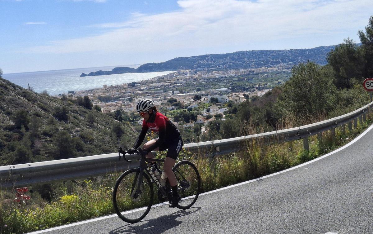 Una ciclista asciende desde el tramo de Xàbia de la carretera de les Planes