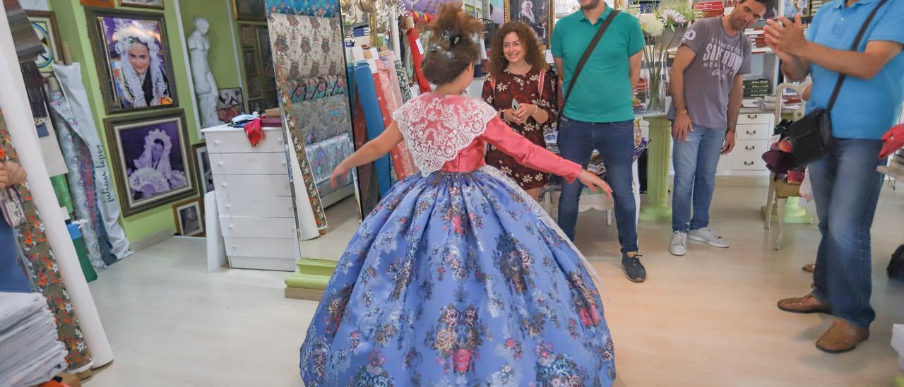 Una niña se prueba un vestido para las pasadas Hogueras