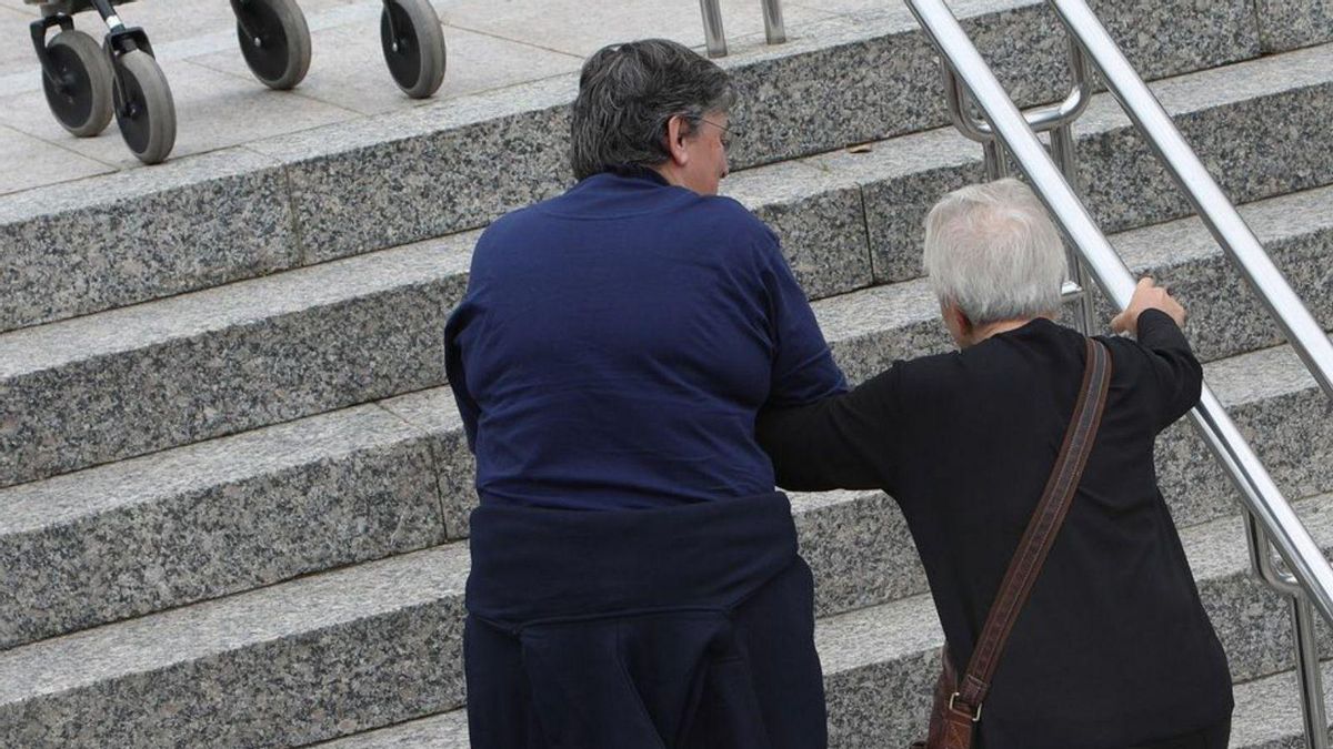 Una cuidadora ayuda a una persona con dependencia.