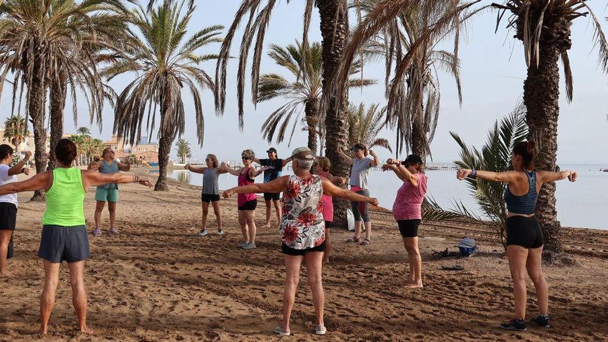 Un grupo de personas realizan gimnasia de mantenimiento en la playa de Los Urrutias, en Cartagena. | J.M.L.A.