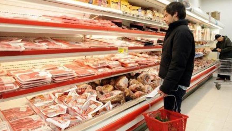 Un client davant d&#039;un lienal de carn en un supermercat