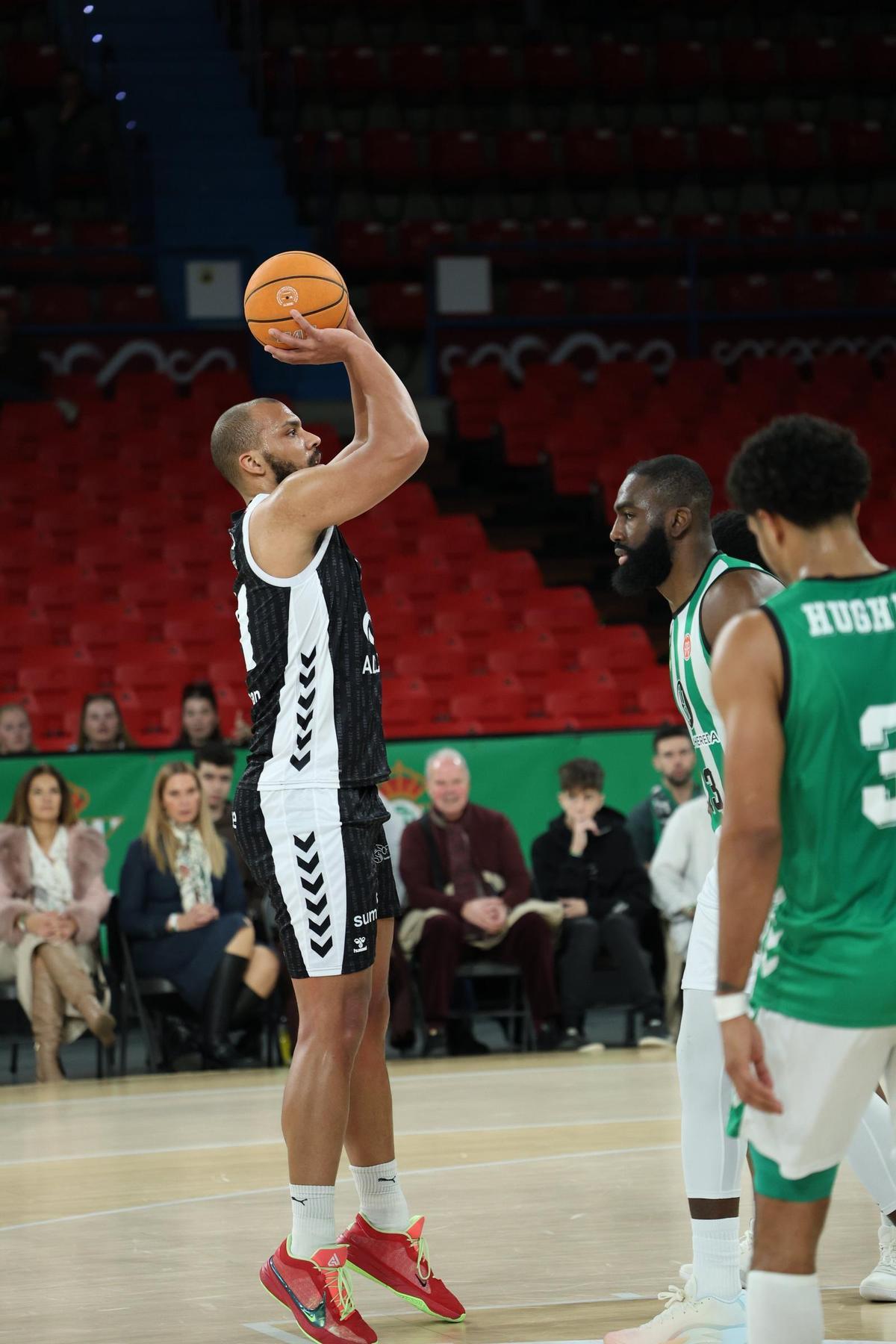 Larsen se prepara para realizar un lanzamiento ante la defensa de varios jugadores del Real Betis.