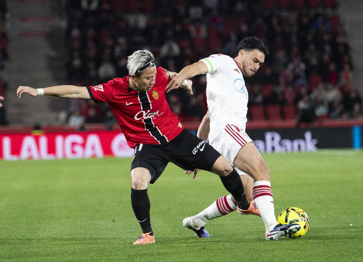 Asano pugna el balón con Suazo durante el partido ante el Sevilla en Son Moix.
