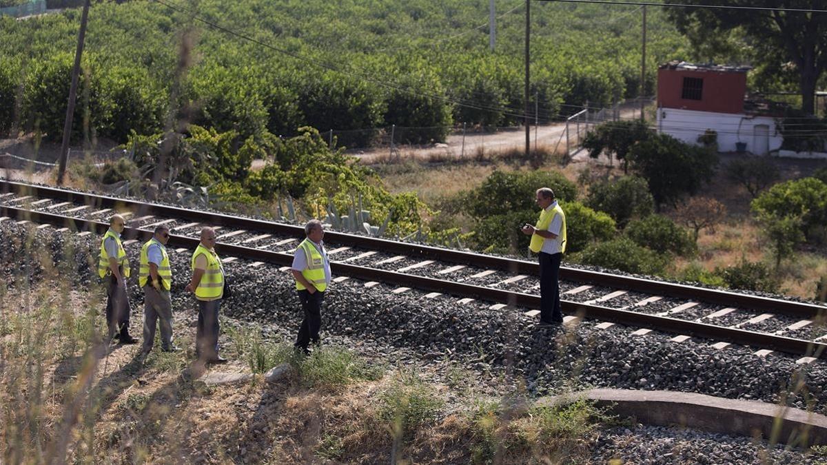 Un guardia civil inspecciona la zona acotada de la via ferrea donde un maquinista ha encontrado el cuerpo de Lucia Vivar Hidalgo