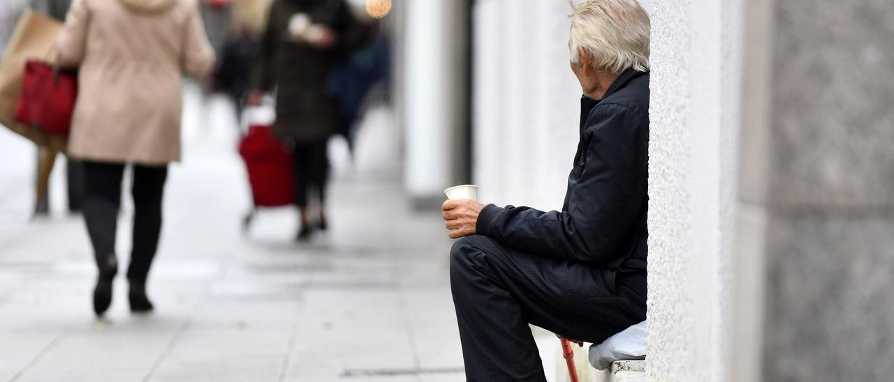 Una persona pide limosna en la calle.