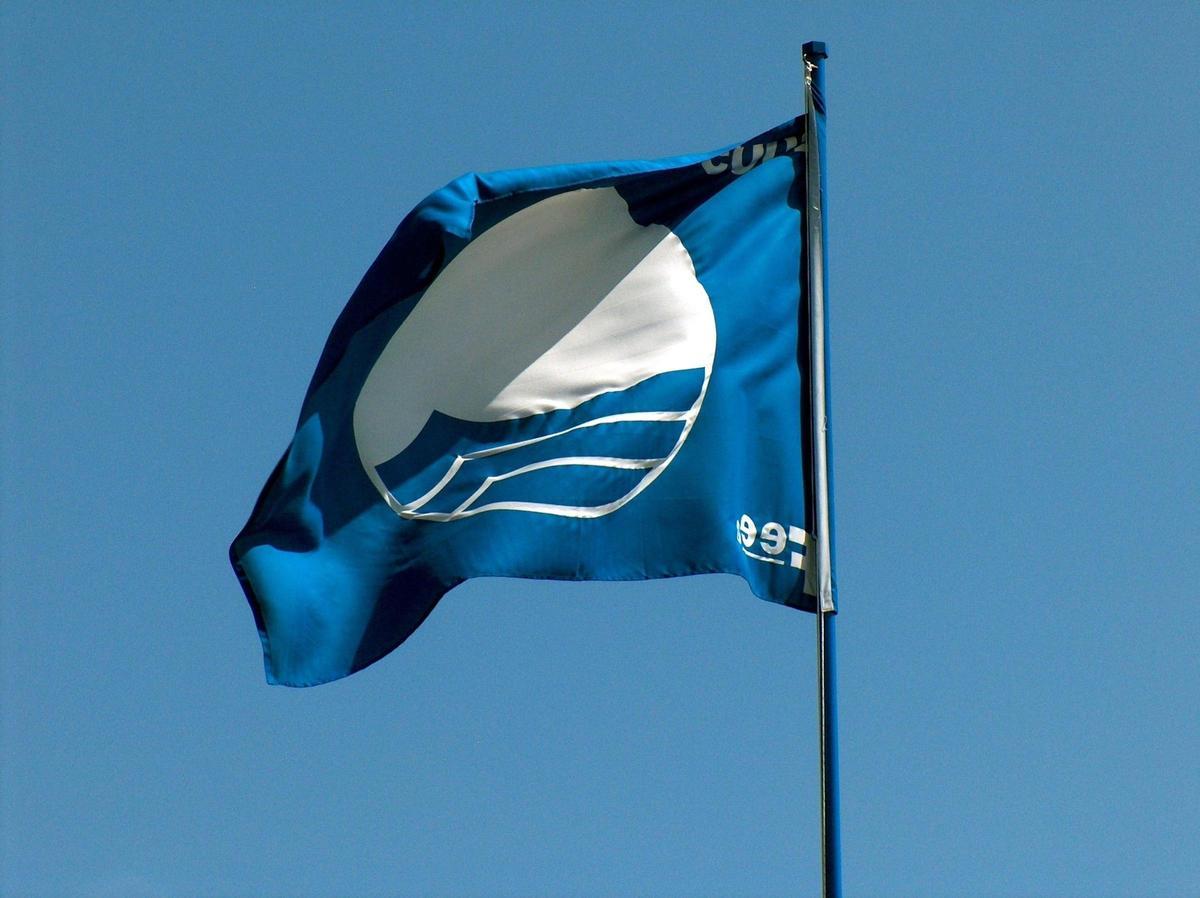 Una bandera azul ondea en una playa