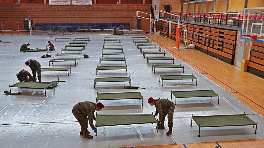 Dos militares montan las nuevas camas en el polideportivo El Cabanyal-El Canyamelar.