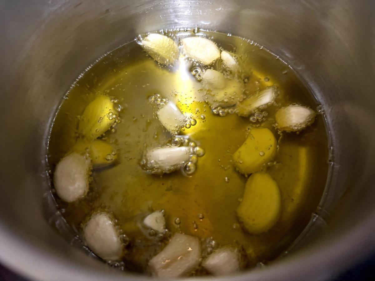 Los ajos, confitándose en aceite de oliva.