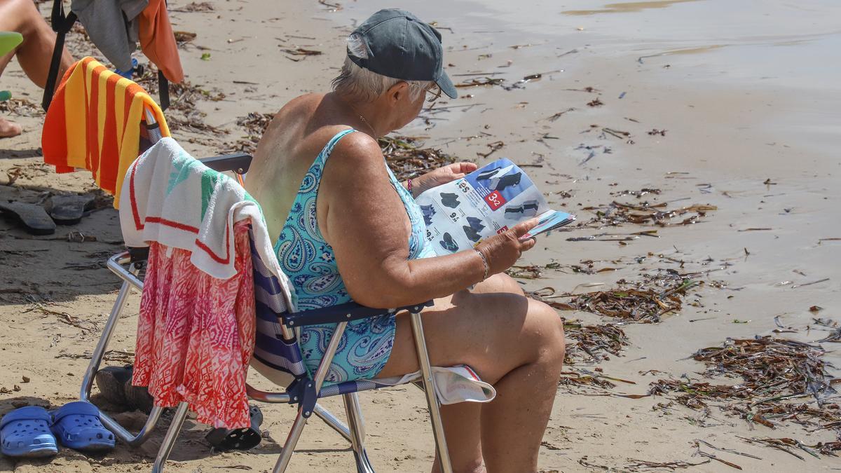 Una mujer toma el sol en la playa del Cura de Torrevieja