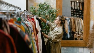Una mujer busca una prenda en una tienda vintage.