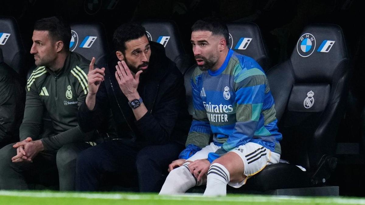 Álvaro Arbeloa conversando con Carvajal en el banquillo