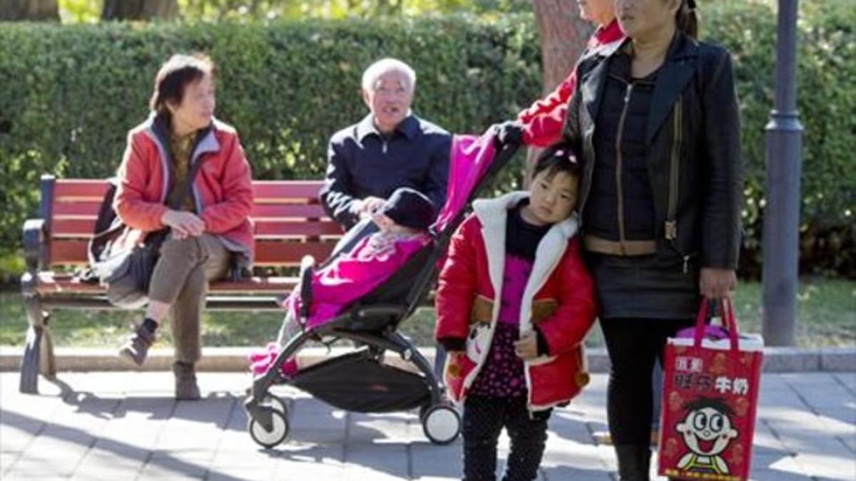 En el parque 8Una niña apoya su cabeza sobre la cadera de una mujer en Pekín, el viernes.