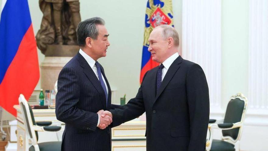 Vladímir Putin estrecha la mano del jefe de la diplomacia china, Wang Yi.