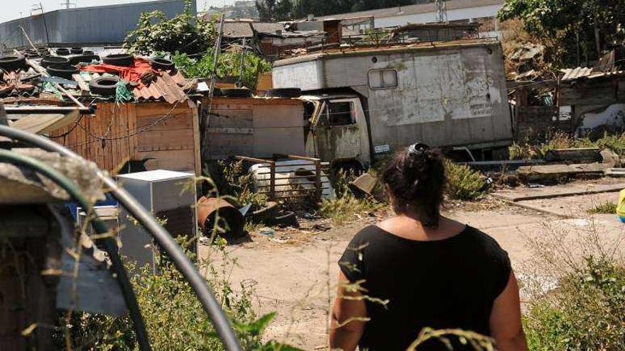 Una mujer, entre algunas de las chabolas de A Pasaxe. 13fotos