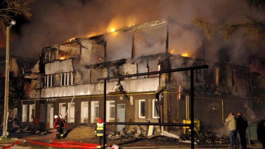 Foto facilitada por la Policía Polaca que muestra a los bomberos mientras intentan controlar un incendio en el albergue social de Kamien Pomorski (noroeste de Polonia), que causó en la madrugada de hoy, lunes 13 de abril, al menos 21 muertos y 20 heridos.