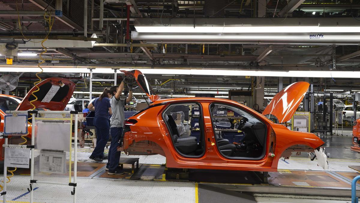 Varios trabajadores en una de las línea de producción de la planta automovilística de Stellantis en Figueruelas.