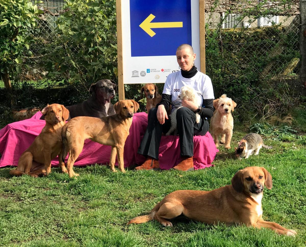 De esquerda á dereita; as cadelas Vega, Polaris (no chan), Pilar, Sol, Linda, Tambre, Tempel (a gata), Xúpiter (en primeiro plano) xunto á xestora de Apaca, Raquel Freiría. Foto: Apaca