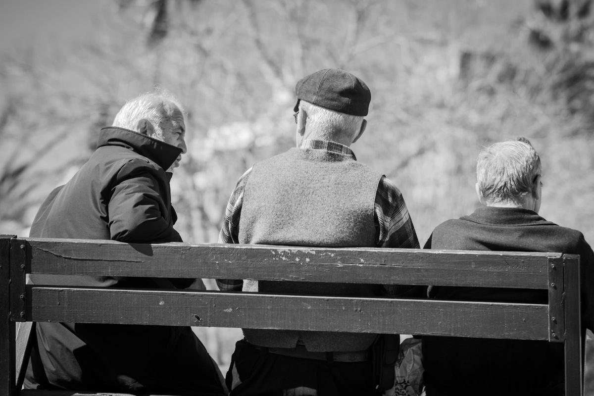 Tres personas mayores sentadas en un banco