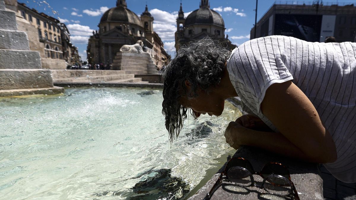 Una persona se refresca en una fuente.