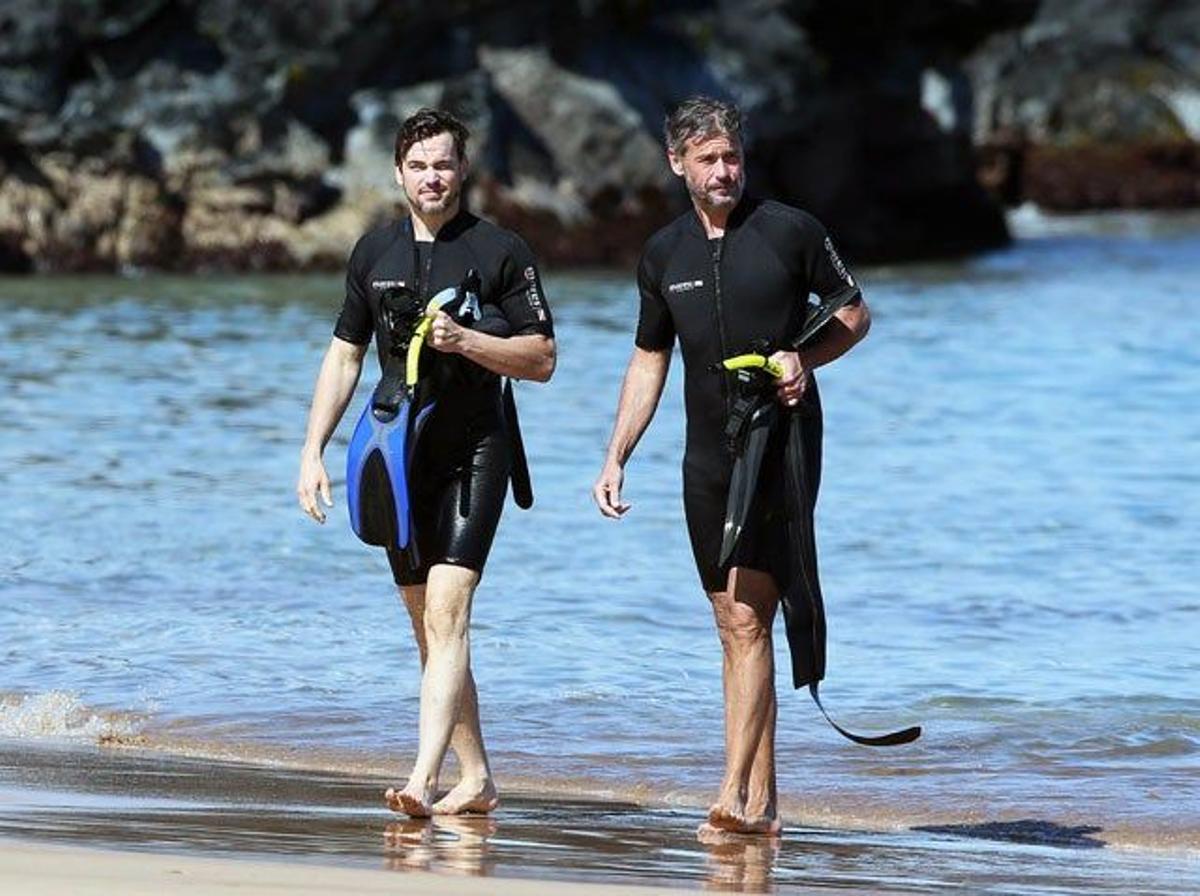 Matt Bomer y Simon Halls saliendo del agua con su traje de neopreno y sus aletas