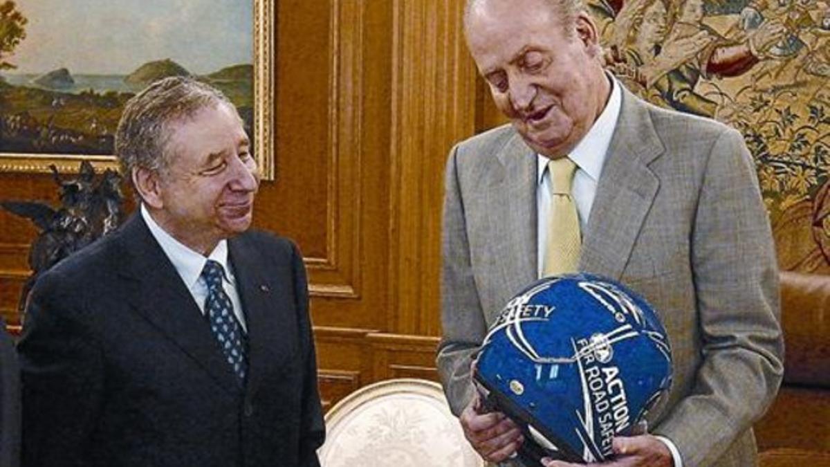 El Rey, con un casco del piloto Michael Schumacher regalado por el presidente de la FIA, Jean Todt, ayer.