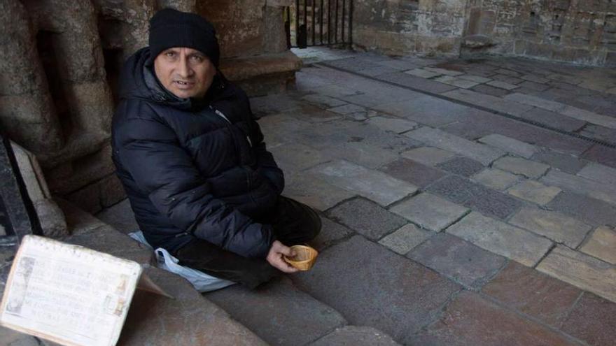 Un mendigo pidiendo a las puertas de la Catedral de Oviedo.