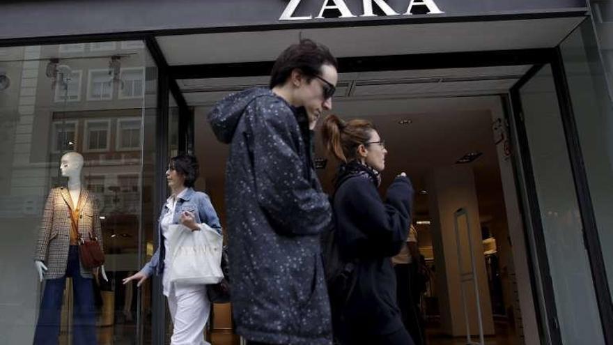 Peatones caminan frente a una tienda de Zara en Madrid. // Reuters/A.C.