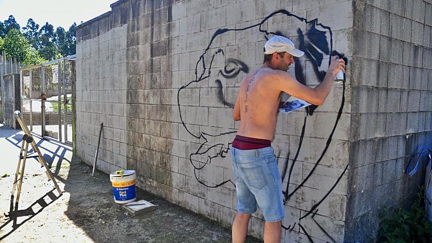 David Oliveira, DOSEK, 
posa con el mural ya finalizado.   | // FDV