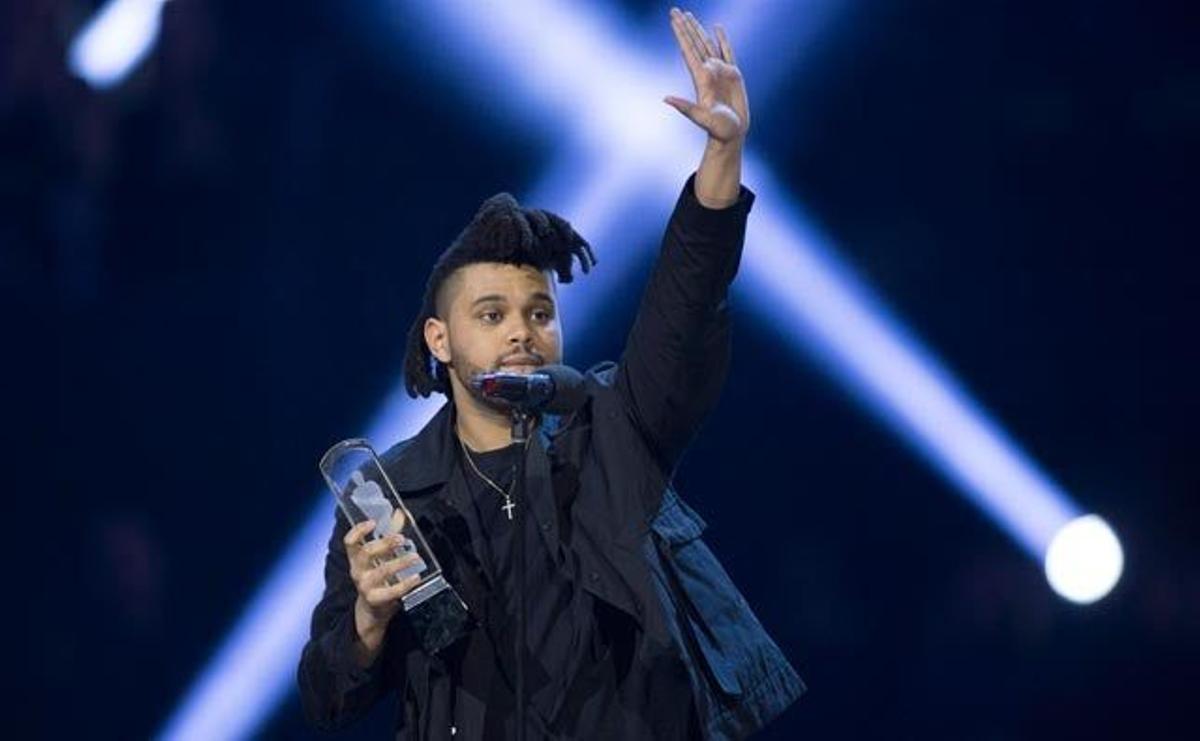 The Weeknd posa feliz con su premio en la gala iHeartRadio Awards 2016.