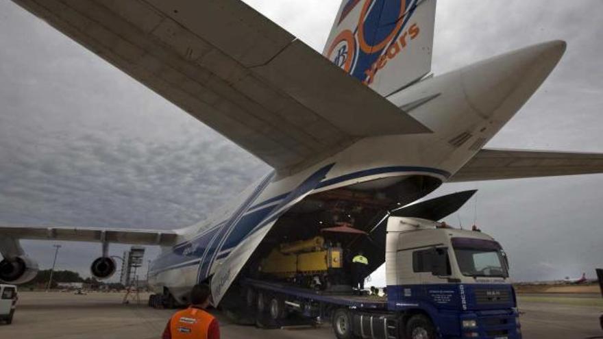 Un camión cargado con una parte de la maquinaria saliendo de la bodega del avión.