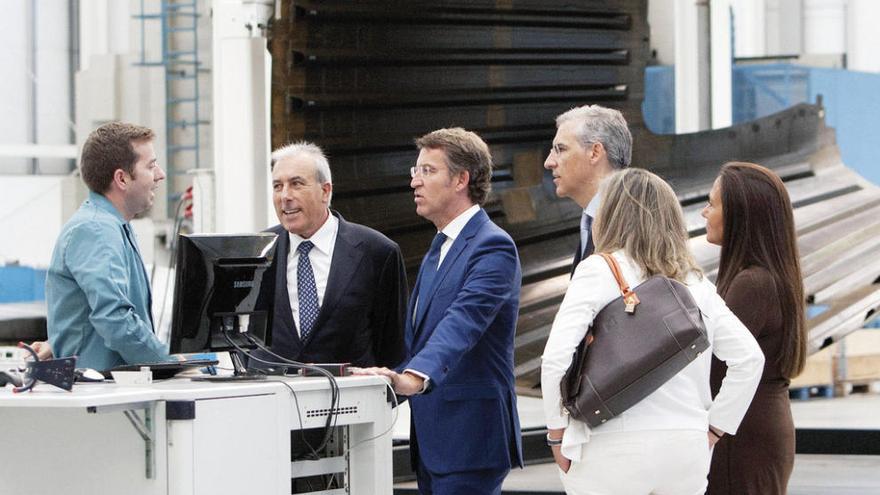 Feijóo (c.) conversa con un trabajador de Delta Vigo (i.) en presencia de Francisco Puga (2i.), Francisco Conde (3d.), Teresa Pedrosa (2d.) y María José Bravo Bosch (d.), en las instalaciones de Valadares.