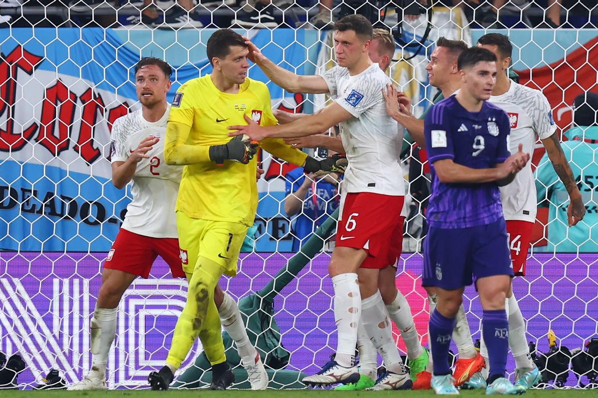 Wojciech Szczesny es felicitado por sus compañeros tras parar el penalti a Leo Messi en el Argentina-Polonia del Mundial de Catar
