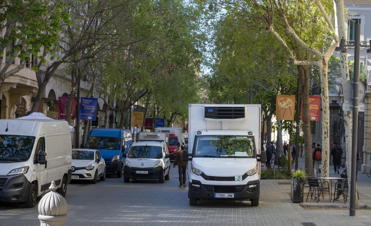 Barcelona. 03.04.2024. Barcelona. Vegetación de los ejes verdes en su primera primavera. En la foto, furgonetas de reparto en la calle Consell de Cent . Fotografía de Jordi Cotrina