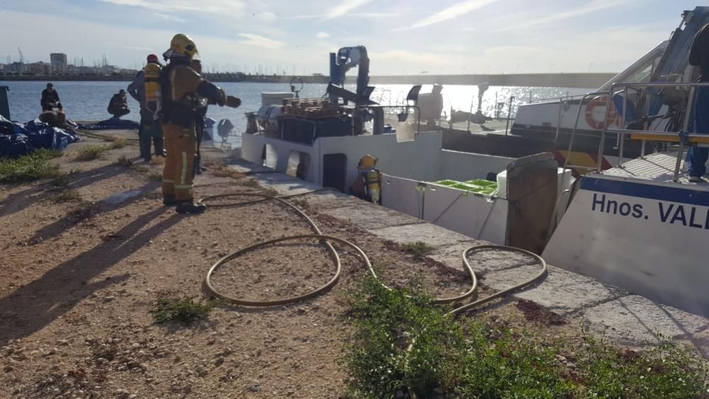 Los bomberos extinguen el fuego en un barco pesquero en Torrevieja