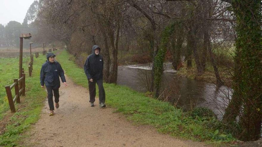 Suárez y Rajoy (derecha) caminan junto a un río Armenteira muy crecido en caudal. // Noé Parga