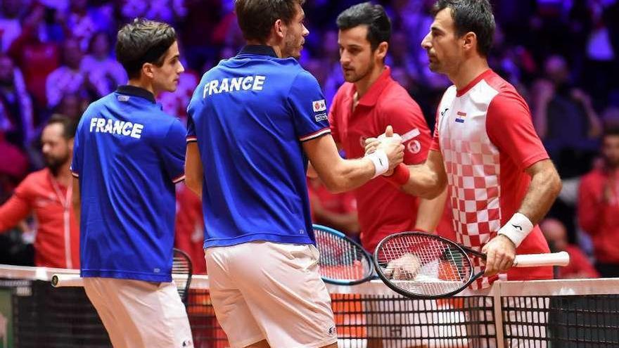 Franceses y croatas se saludan al término del partido de dobles.