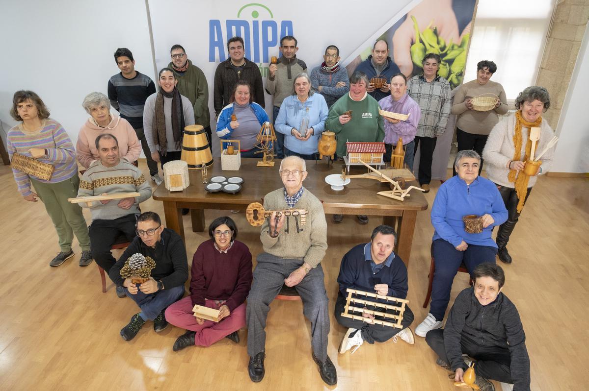 Gerardo Lago Piñeiro, delante, en el centro, con miembros de la asociación Amipa, que sostienen las piezas que donó a la entidad.