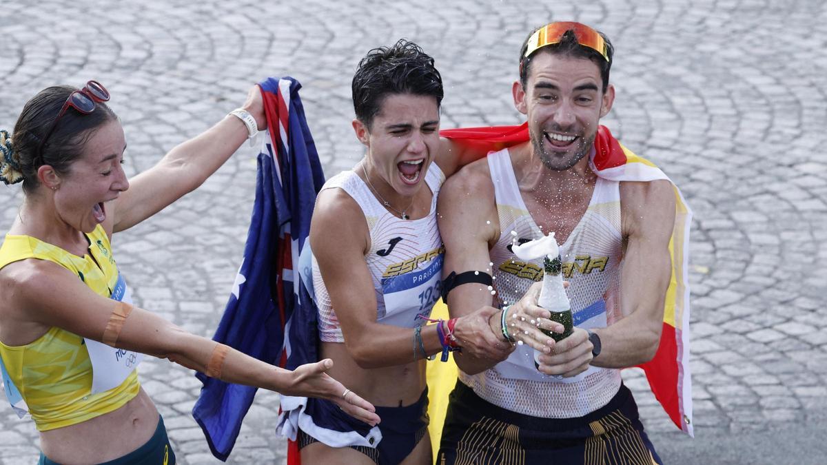 Las medallistas de oro María Pérez y Álvaro Martín junto a la medallista de bronce, la australiana Jemima Montag celebrando con champán su triunfo en la prueba de marcha por relevos mixtos de los Juegos Olímpicos de París 2024