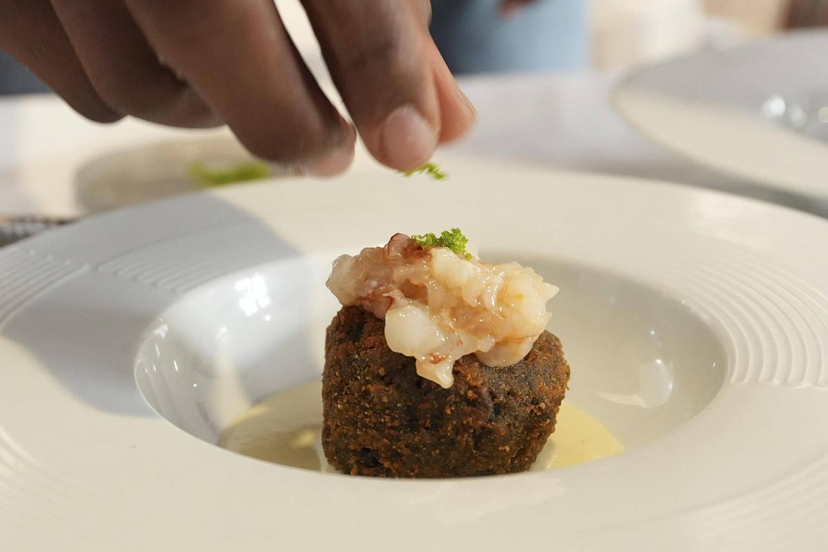 Middleton acabant de preparar un arancino negre amb tàrtar de gamba de Palamós i crema de pecorino.