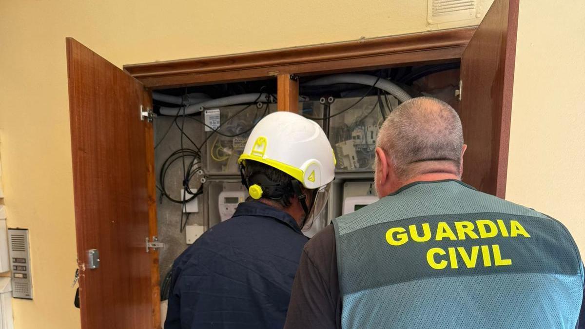 La Guàrdia Civil i un tècnic d'Endesa comprovant connexions.